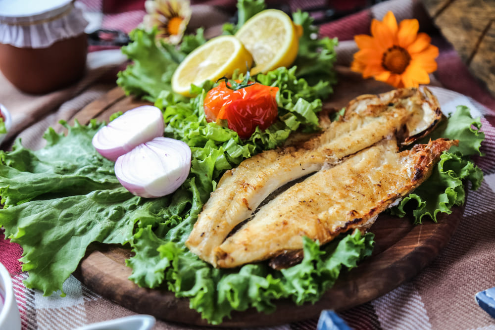 grilled-fish-wooden-board-onion-lettuce-tomato-lemon